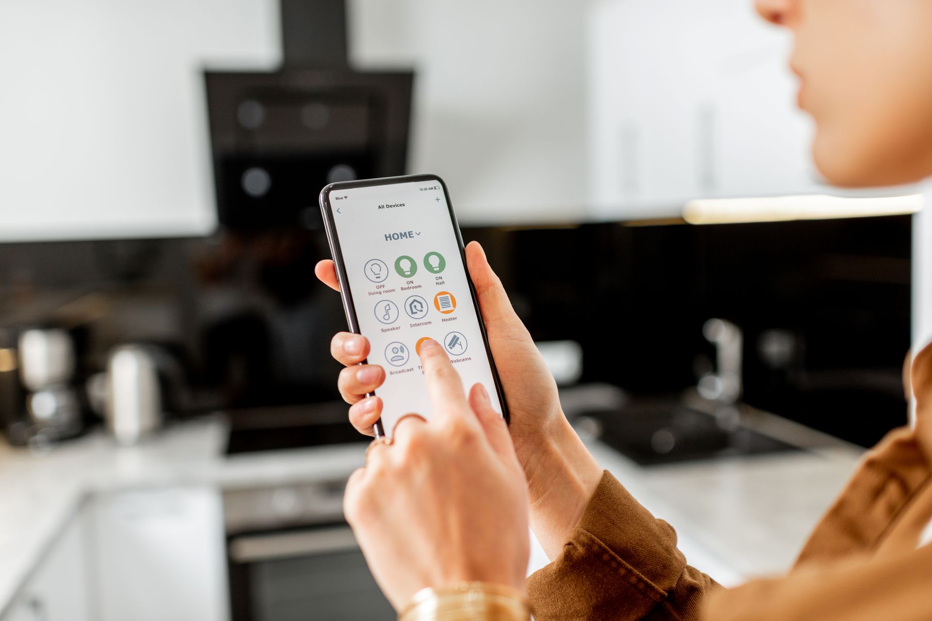 Person bedient smarte Kuechentechnologie mit Smartphone zur Steuerung von Geraeten wie Osmose Wasserfilter