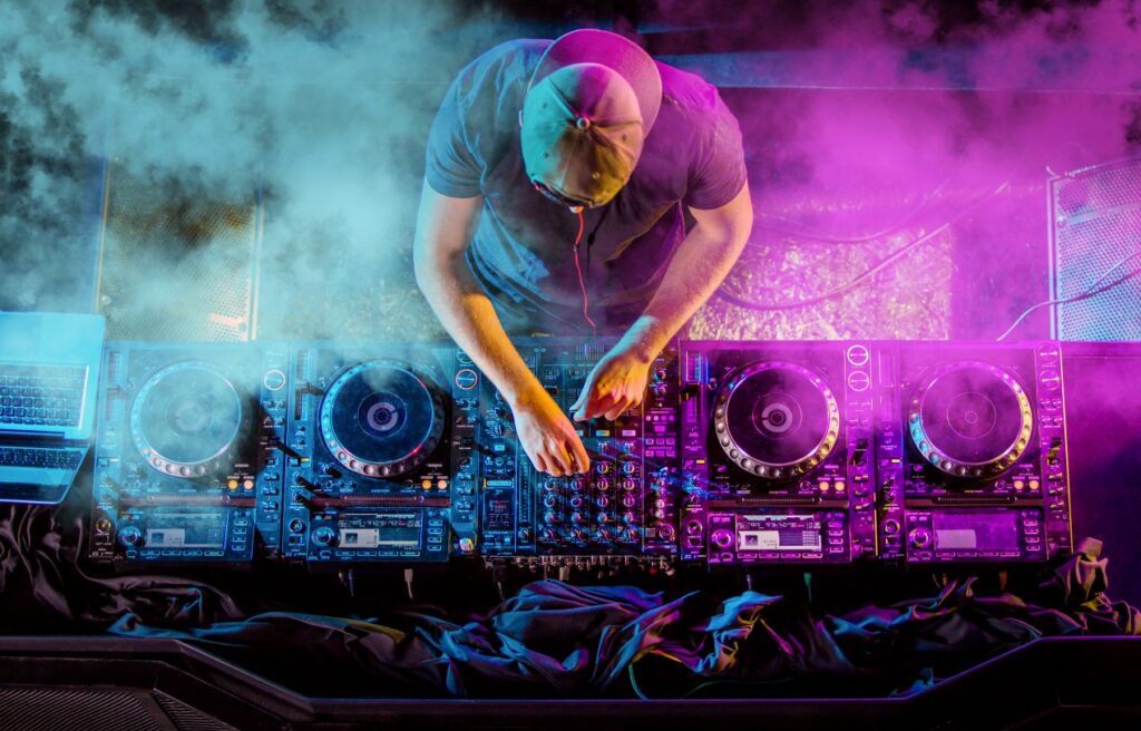 Hochzeits DJ Brandenburg mixt Musik an seinem DJ-Pult mit beeindruckender Licht- und Nebelshow – perfekte Stimmung für die Party.