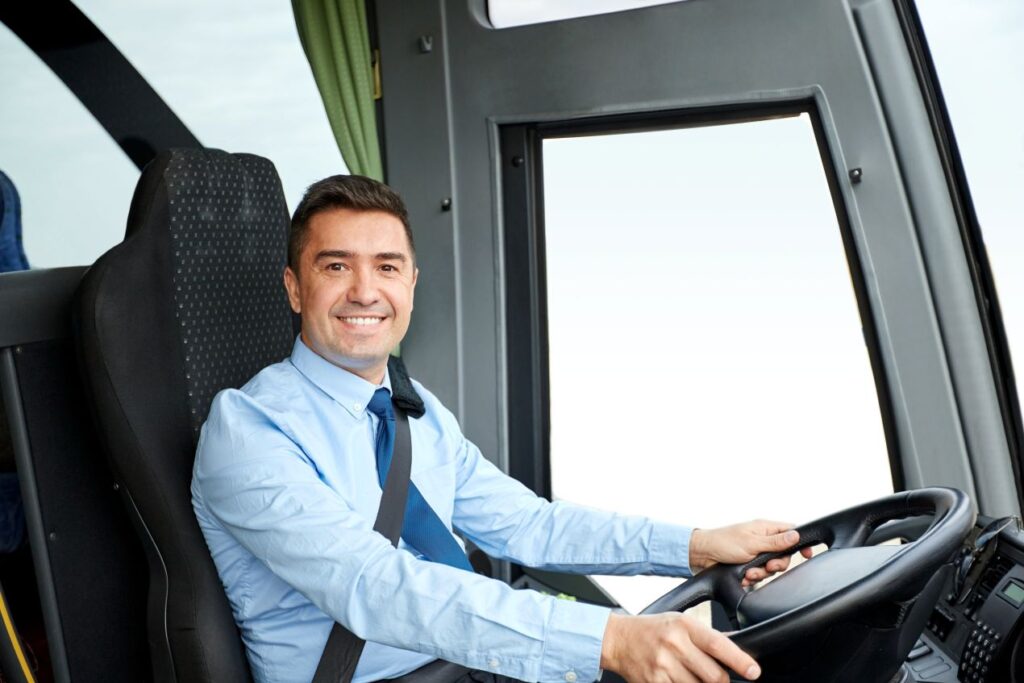 Mann im Anzug fährt einen Flughafen Shuttle Frankfurt Bus und blickt freundlich in die Kamera